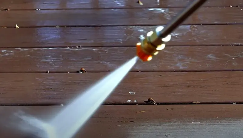 High-pressure water jet cleanses weathered deck boards