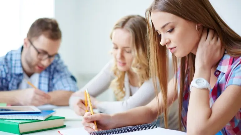 Students focus on writing admissions essays during a study session as application expectations tighten