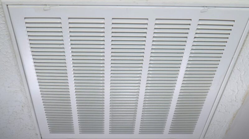 A clean, white ceiling vent, showcasing a precise grid pattern